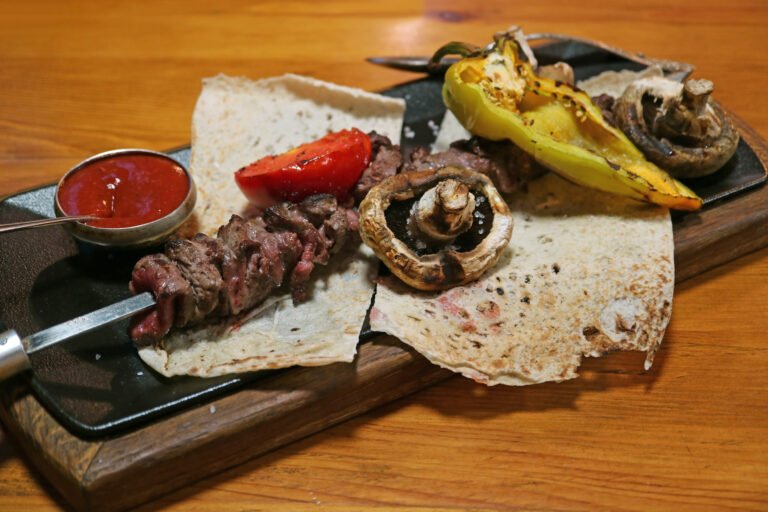 Armenian barbecue khorovats with grilled vegetables served on lavash flatbread