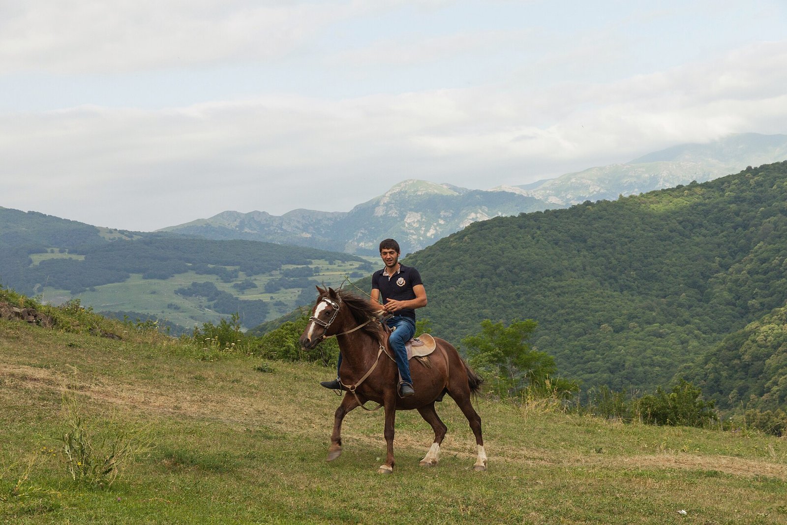 A man on horseback beside Goshavank monastery in Tavush, Armenia
