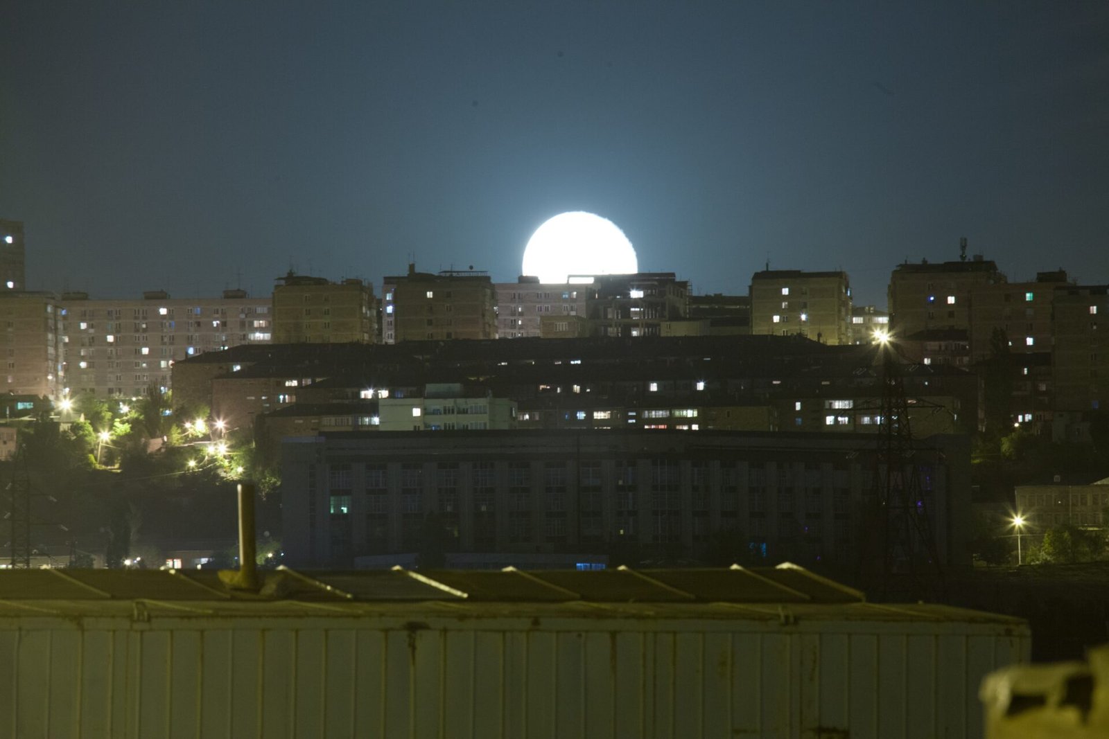 Moon shining over the lit city of Yerevan, Armenia, at night